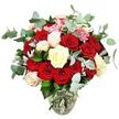 A richly romantic bouquet of roses sits in a clear glass vase, photographed against an immaculate white background that makes every colour glow. At first glance, the numerous deep red and bright scarlet roses steal the attention, their velvety petals full and layered, some only just opening and others completely unfurled, creating a sense of passion and warmth. Threaded through this sea of red are elegant creamy white and soft ivory roses, their lighter hues catching the light and bringing a gentle, soothing balance to the arrangement. Some white blooms carry a delicate blush of pink at the edges, introducing a subtle gradient of colour that softens the transition between white and red and adds emotional depth to the design. Between the larger roses, dainty clusters of bright pink filler flowers, reminiscent of mini carnations or small blossoms, punctuate the bouquet with fine texture and playful splashes of colour. Surrounding the flowers is a frame of blue-green eucalyptus, each leaf rounded and slightly silvery, arching outward in soft curves that give the design a fresh, modern outline and suggest a cool, eucalyptus fragrance. Additional darker green foliage and flashes of silvery-green leaves are tucked beneath the blooms, ensuring the bouquet appears dense, rounded, and abundant from every angle. The clear glass vase has a gently rounded base that narrows towards the top, with the stems neatly gathered and the clear water line visible, signalling freshly arranged, well-cared-for flowers. This arrangement feels perfectly at home in Stanmore, perhaps on a sideboard in a house near Bentley Priory or as a central feature in a light-filled kitchen, ideal for anniversaries, heartfelt apologies, or any special moment that calls for classic, elegant romance.