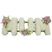 A tender sympathy tribute spelling 'MOM' in three substantial, three-dimensional letters, each letter completely covered with compact, snowy-white spray chrysanthemums that give a cloud-like, velvety surface. The white massing reads as a gentle, luminous field, the blooms packed tightly so the light seems to rest on each tiny petal, evoking purity and quiet. At the upper left of the first 'M' a small cluster of soft lavender and blush-pink roses nestles amid deep green fern fronds, their velvety petals and subtle perfume cutting through the cool white with a warm, comforting note. A matching pastel grouping sits at the base of the central 'O', and the right-hand 'M' carries a mirrored cluster on its upper right curve; each accent is placed with the deliberate, balanced hand of a florist experienced in funeral work. Dark green structural framing - a ribbon-wrapped base or moss-covered board - is visible beneath the blooms, creating a shadowed outline that anchors the letters and keeps the composition elegant and stable. The overall impression is hushed and reverent: the white chrysanthemums suggest peace and remembrance, while the pale roses introduce tenderness and personal memory. The scent is soft, green and slightly sweet, the texture a contrast between fluffy white heads and the smooth, satiny rose petals, with fern tips adding a feathery finish. Intended for a funeral service, memorial or graveside dedication, this classic tribute communicates love and respect for a mother, arranged with careful symmetry and a quiet dignity suited to local services in and around Stanmore and nearby Canons Park.
