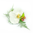 A serene, wearable study in white and green: a single pristine Phalaenopsis orchid takes centre stage, its broad, satiny petals spreading like a small white sail and catching the soft studio light with a faint, waxy sheen. At the heart of the bloom a warm throat of pale yellow and honeyed gold, flecked with the faintest brown, adds depth and the sense of a quiet, intimate glow. Surrounding the orchid, wisps of asparagus fern fan outward with feathery, almost tulle-like texture, reaching to the left and cascading gently to the right to create an airy, asymmetrical silhouette. To the right a cluster of glossy, reddish-pink hypericum berries provides a cheerful counterpoint, their rounded shapes and slight sheen bringing a little rustic richness against the orchid's pristine calm. Nestled nearer the base, a compact, lime-green chrysanthemum or similar filler adds a bright, verdant punctuation that lifts the arrangement with youthful energy. The composition reads as a refined boutonniere or wrist corsage-compact and balanced despite its directional flow-designed to be pinned to a lapel or worn at the wrist for weddings, proms, or other formal moments. The clean white background keeps the focus entirely on texture and tone: silk-smooth petals, feathery greens, glossy berries and the tactile density of the green mum. As a piece crafted with attention to tactile contrast and understated romance, it evokes the hush of first light and the fresh, green scent of foliage-an elegant accent meant to be both seen and softly remembered in a quiet, celebratory moment in Stanmore.