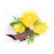 A petite, handcrafted corsage captured against a clean white backdrop, where three sunlit yellow roses take centre stage, each petal velvety and warmly saturated like a Stanmore summer afternoon. The largest rose opens fully in the middle, balanced by two slightly smaller, half-open roses either side; each has a tiny clear rhinestone nestled at its heart, catching light and adding a discreet, sparkling note to the composition. Just beneath this trio a single, sculptural calla lily in a deep plum or burgundy curves downwards and left, its satin-like throat and dramatic silhouette providing a rich, moody counterpoint to the luminous yellows. Wisps of asparagus fern thread through the arrangement, their feathery texture softening the edges, while broader dark green leaves form a supportive base. Scattered among the roses are small, button-style white chrysanthemums that read like tiny pinpricks of cream, and a couple of closed green buds peek from the lower right, suggesting the arrangement is alive and still unfolding.

As a local florist who often designs for proms and weddings near Stanmore Broadway and Canons Park, I imagine this corsage pinned to a jacket lapel or a delicate wrist ribbon, the crystal centres glinting in gallery light or under the soft glow of a church hall. A sliver of sheer white lace or feathering behind the left-most rose adds a romantic, vintage whisper. The scent would be gentle-soft rose perfume with a hint of green from the foliage-an elegant, joyful accent for a special day in Stanmore or the surrounding Harrow neighbourhood.